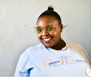A woman wearing a DREAMS t-shirt