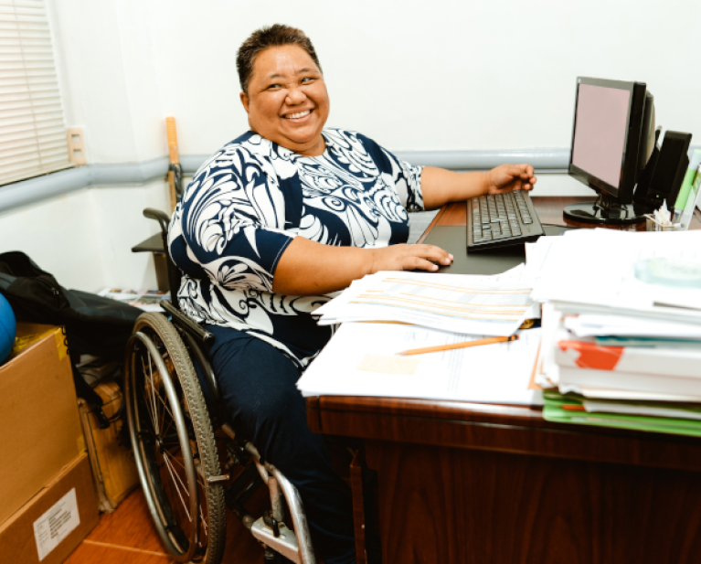 woman in wheelchair at office desk