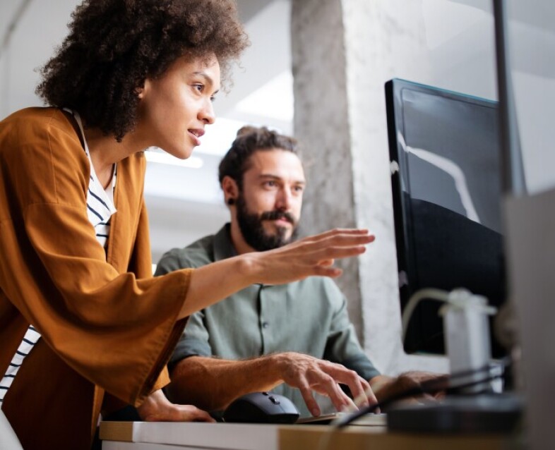 man and woman looking at computer screen