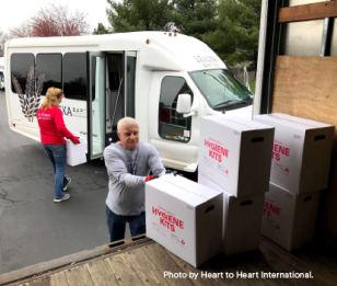 A man and woman load Johnson & Johnson-branded hygiene kits into a truck
